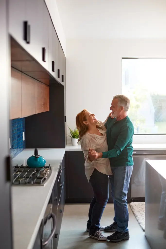 Happy couple dancing in their beautifully renovated kitchen, representing the final step in Indy Rehab Construction’s process: enjoying a newly transformed space that feels like home.